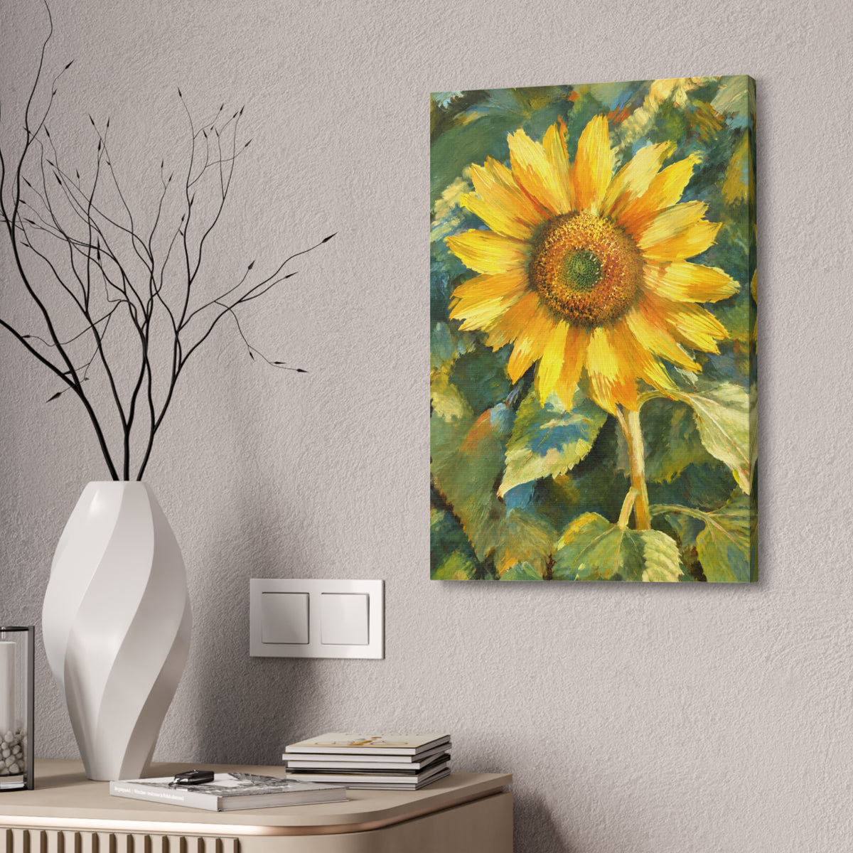 Sunward sunflower canvas hanging on a textured wall beside a white vase of branches above a wood cabinet.