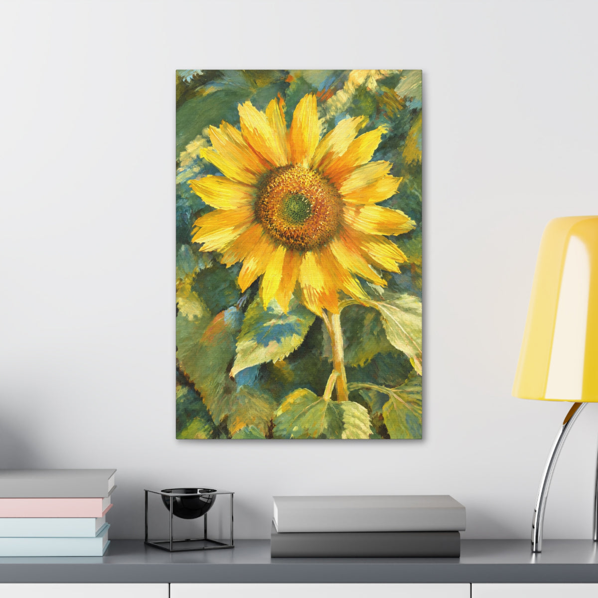 Sunward sunflower canvas displayed above a gray cabinet with books and a yellow lamp.