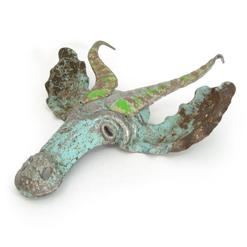Bronze or copper-colored decorative object with green patina on a white background