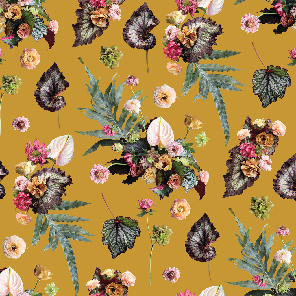 The Little Branch Wallpaper pattern tile in mustard — scattered botanical collage of anthuriums, begonia leaves, ferns, ranunculus, and mixed florals on a warm golden ground by Samantha Santana