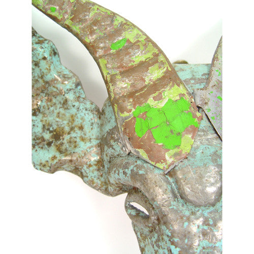 Close-up of a decorative object with green and brown patterns on a white background