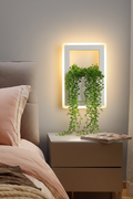 Plant LED Wall Sconce with lush trailing plant cascading over glowing light